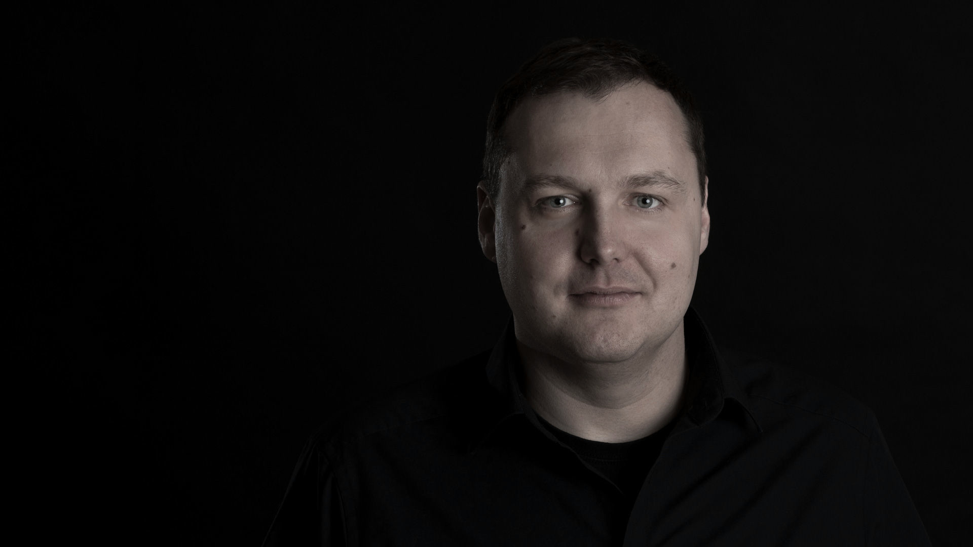 Porträt von Florian Köllich vor dunklem Hintergrund